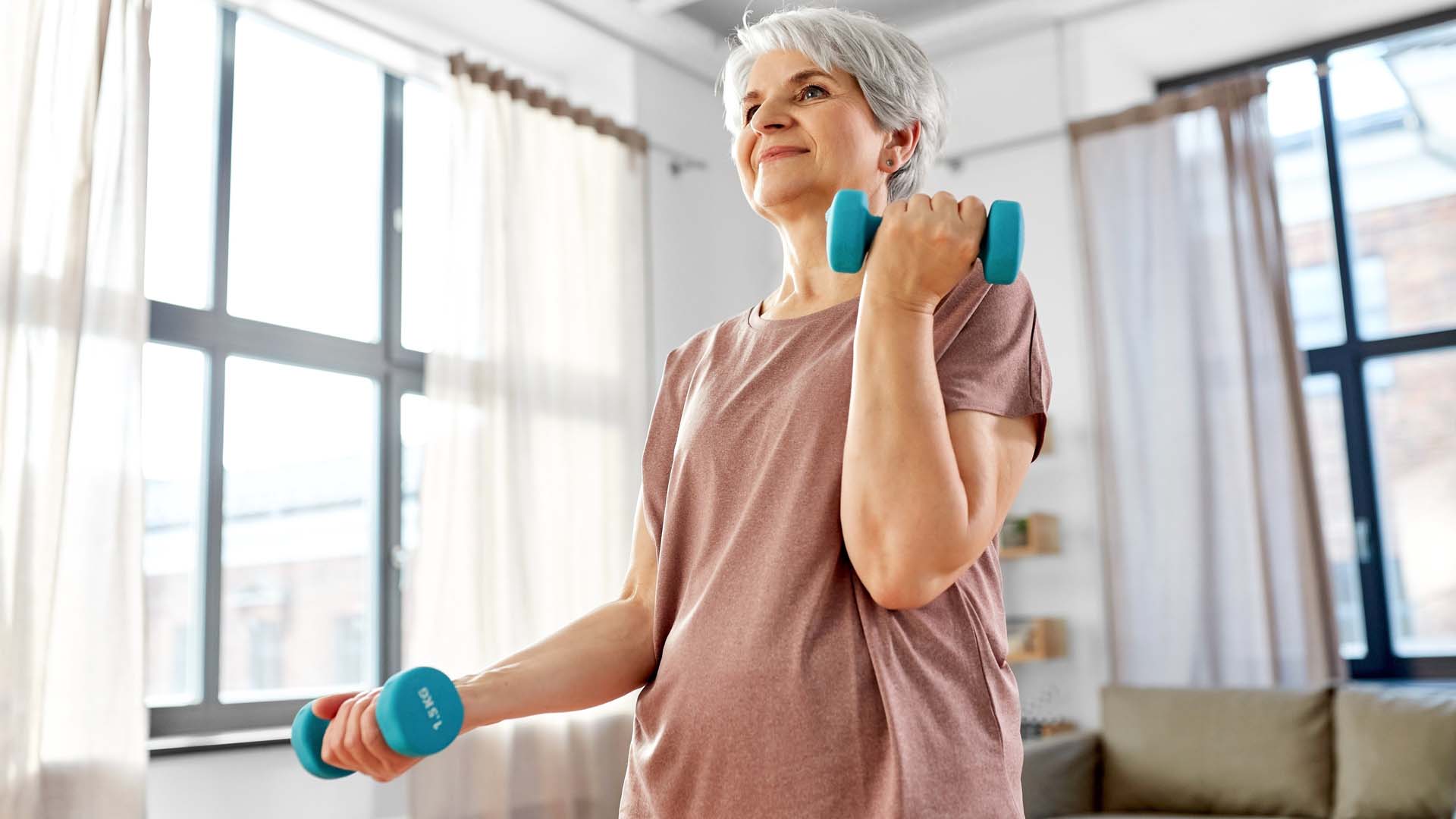 woman doing a bicep curl by a window