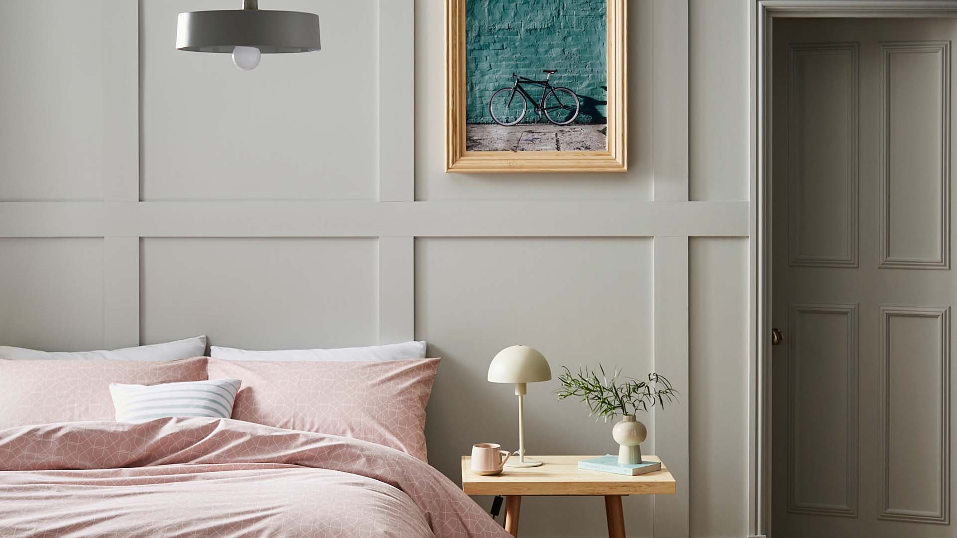 pink bed against dove grey wall panelling
