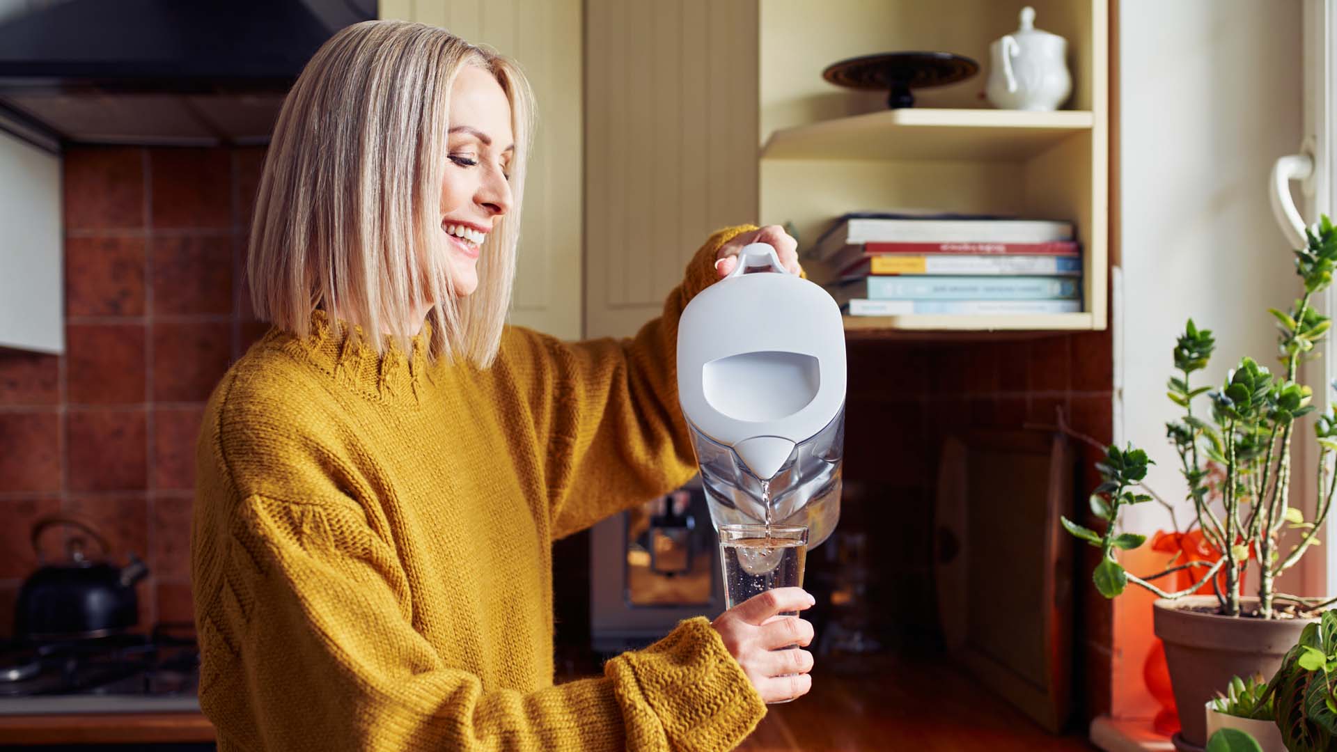 A woman pouring water out of a kettle