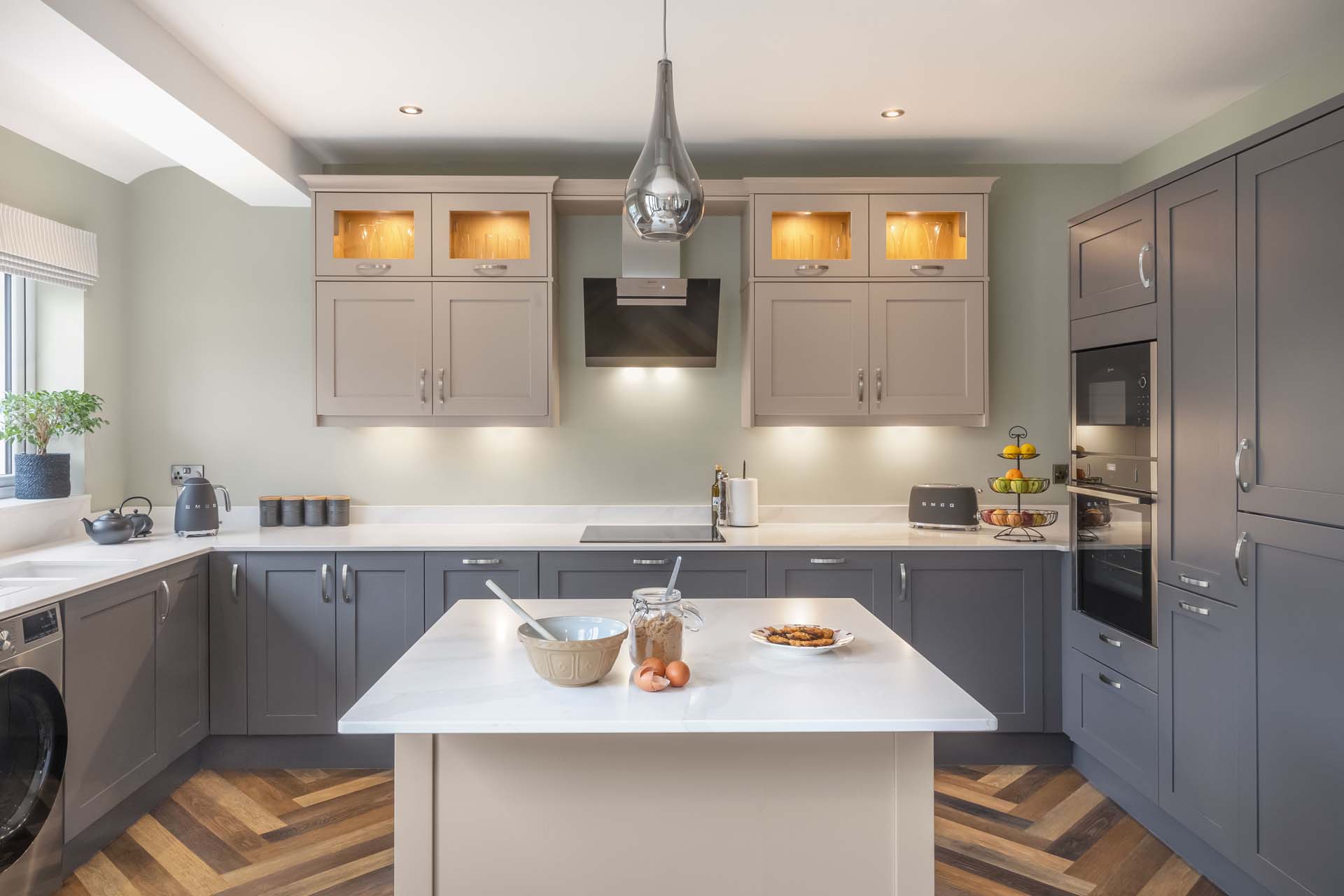 A modern kitchen with island and grey units