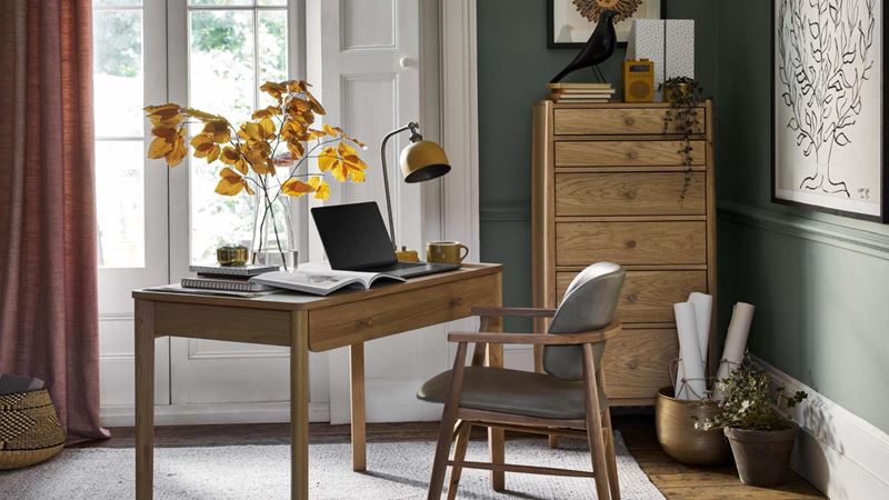 desk in the corner of the room by the window