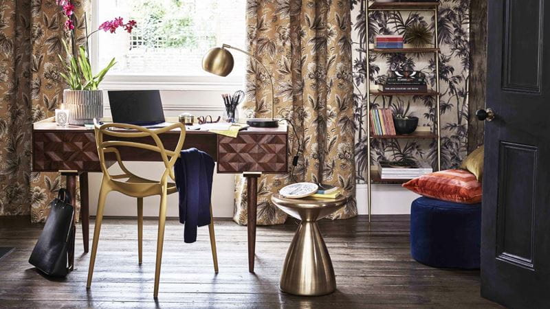 desk in front of the window with a side table and gold chair
