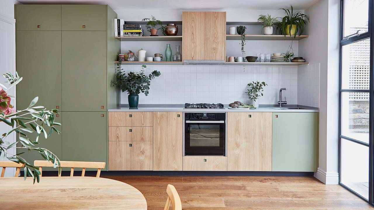 Green and wood look kitchen with a kitchen table in the foreground