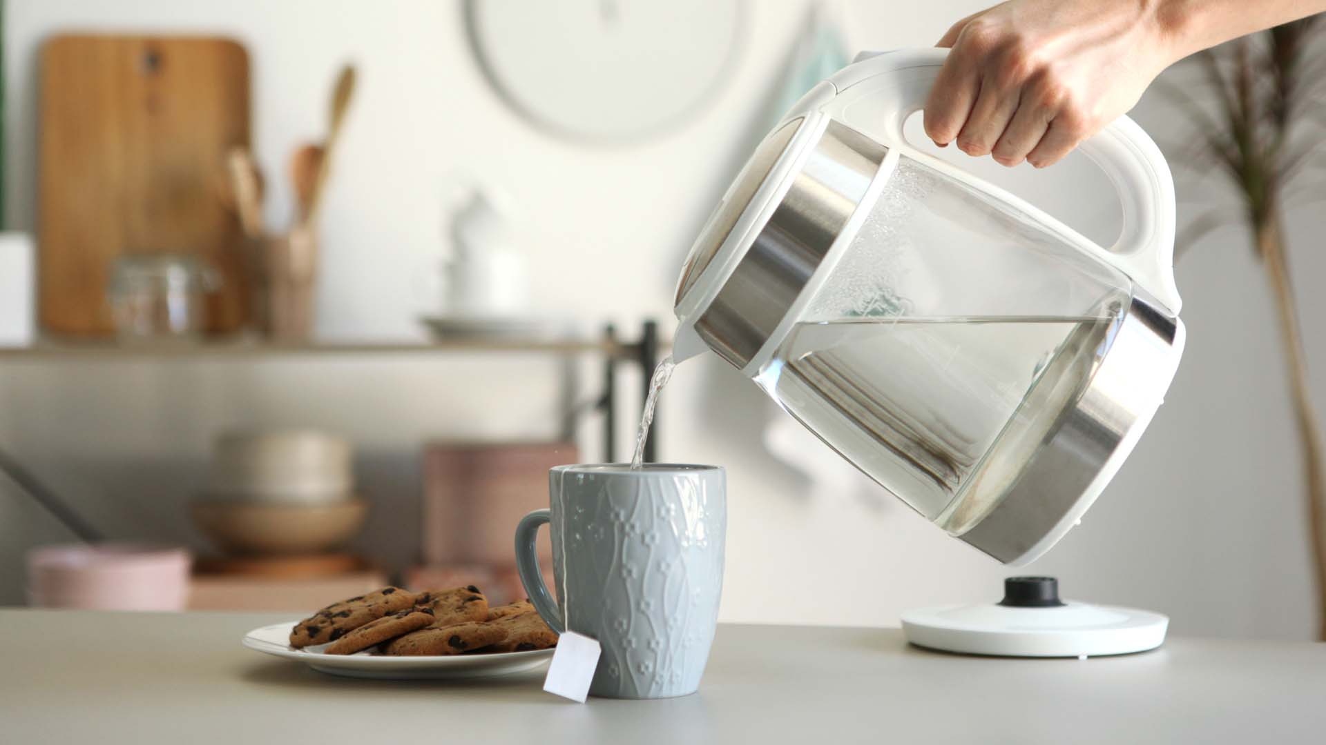 Kettle pouring a water into a tea cup