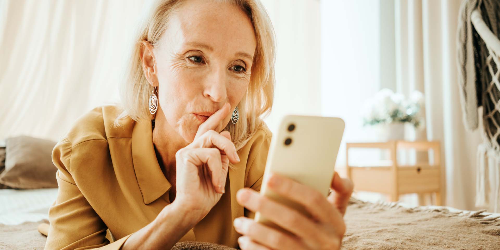 A lady takes a moment to think whilst solving puzzles on her phone