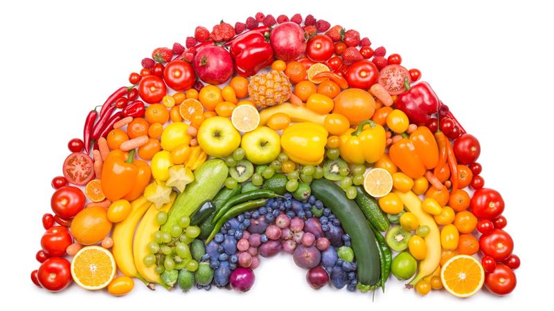 Colourful fruit and vegetables arranged in a rainbow shape