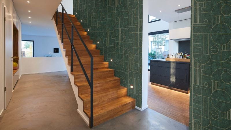 A black steel handrail on a new warm wood staircase