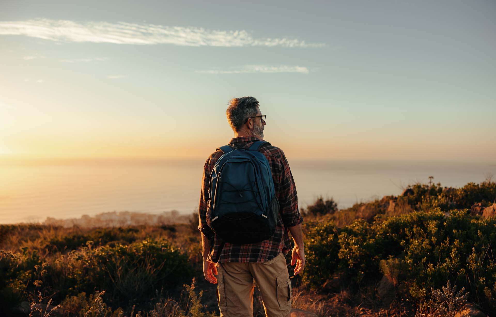 A hiker gazing out into the sunset