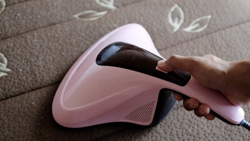 A person vaccuming with a handheld vacuum
