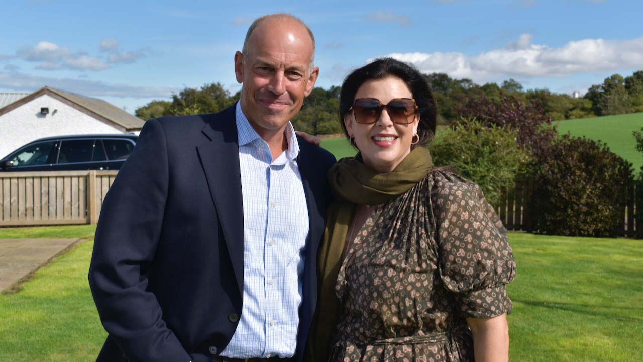 Phil Spencer and Kirsty Allsopp from Channel 4 pose with a house in the background.
