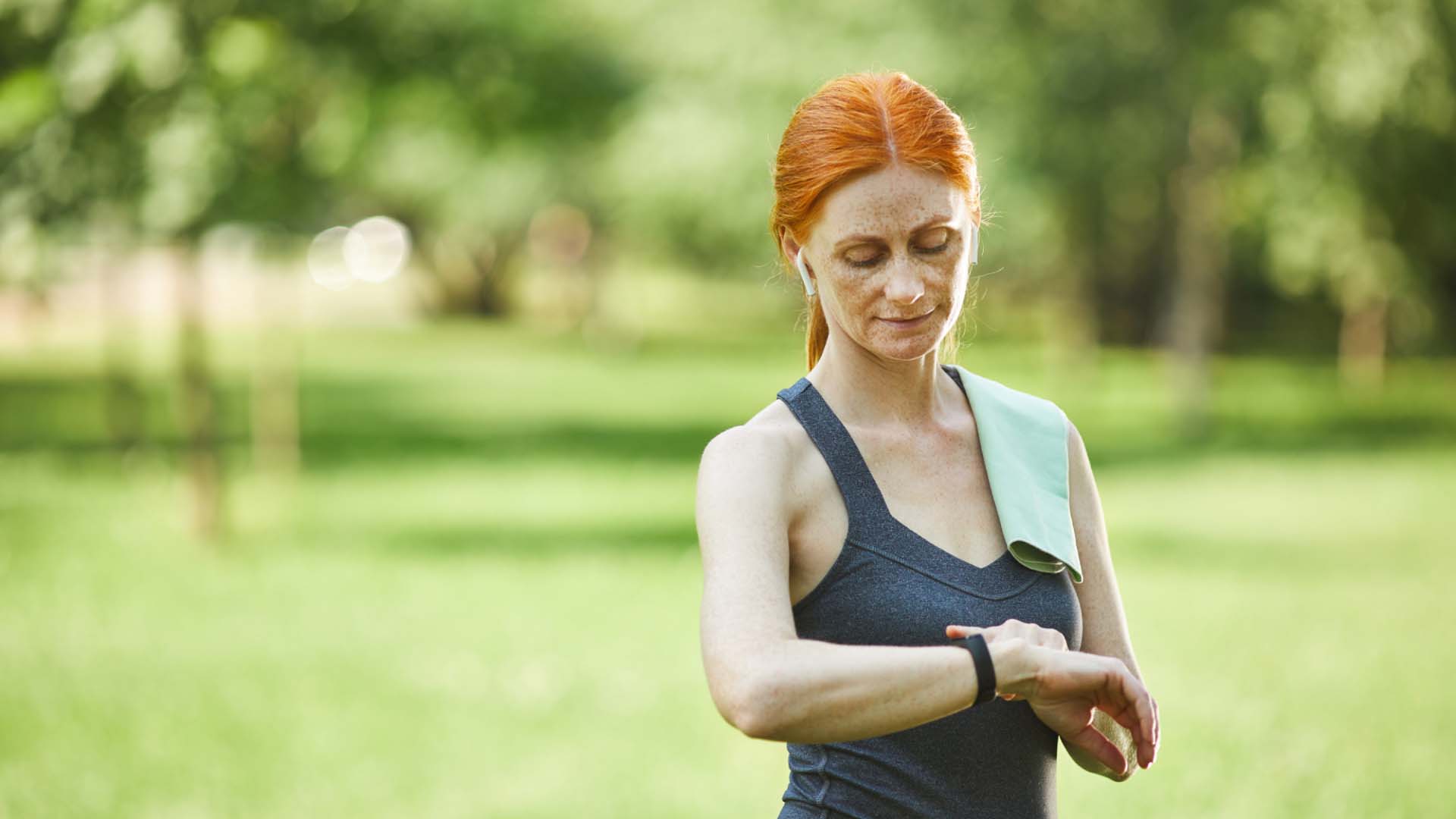 woman checking fitness tracker while out on a run