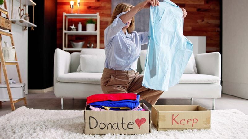 Packing clothes into boxes to move