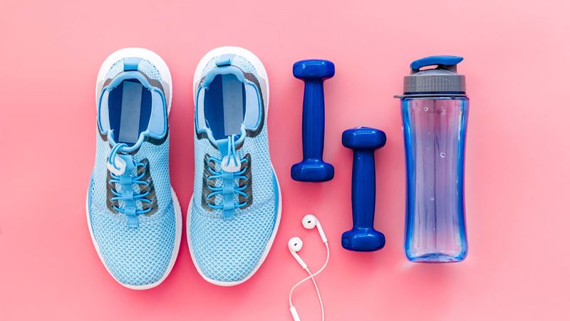 A pair of shoes, weights, a water bottle and earphones