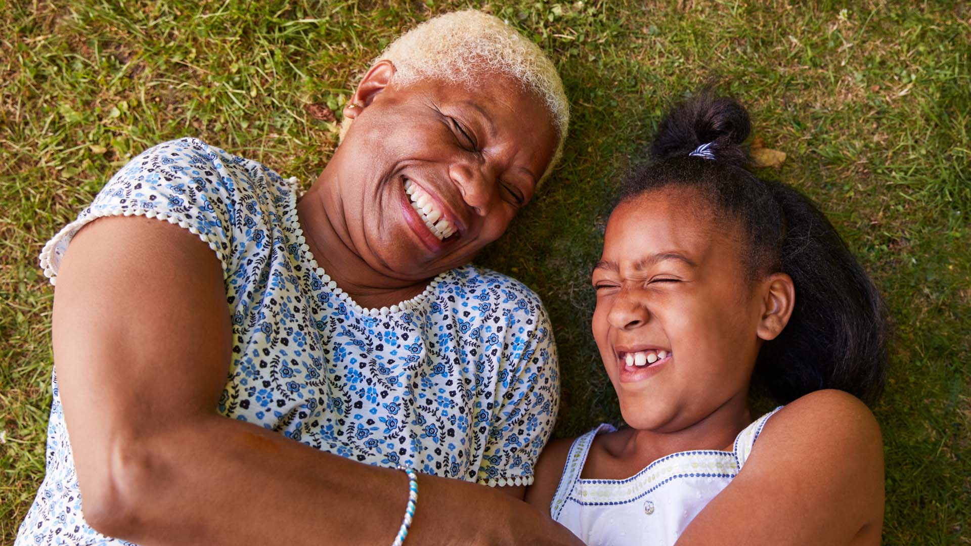 Woman and child laughing on the grass