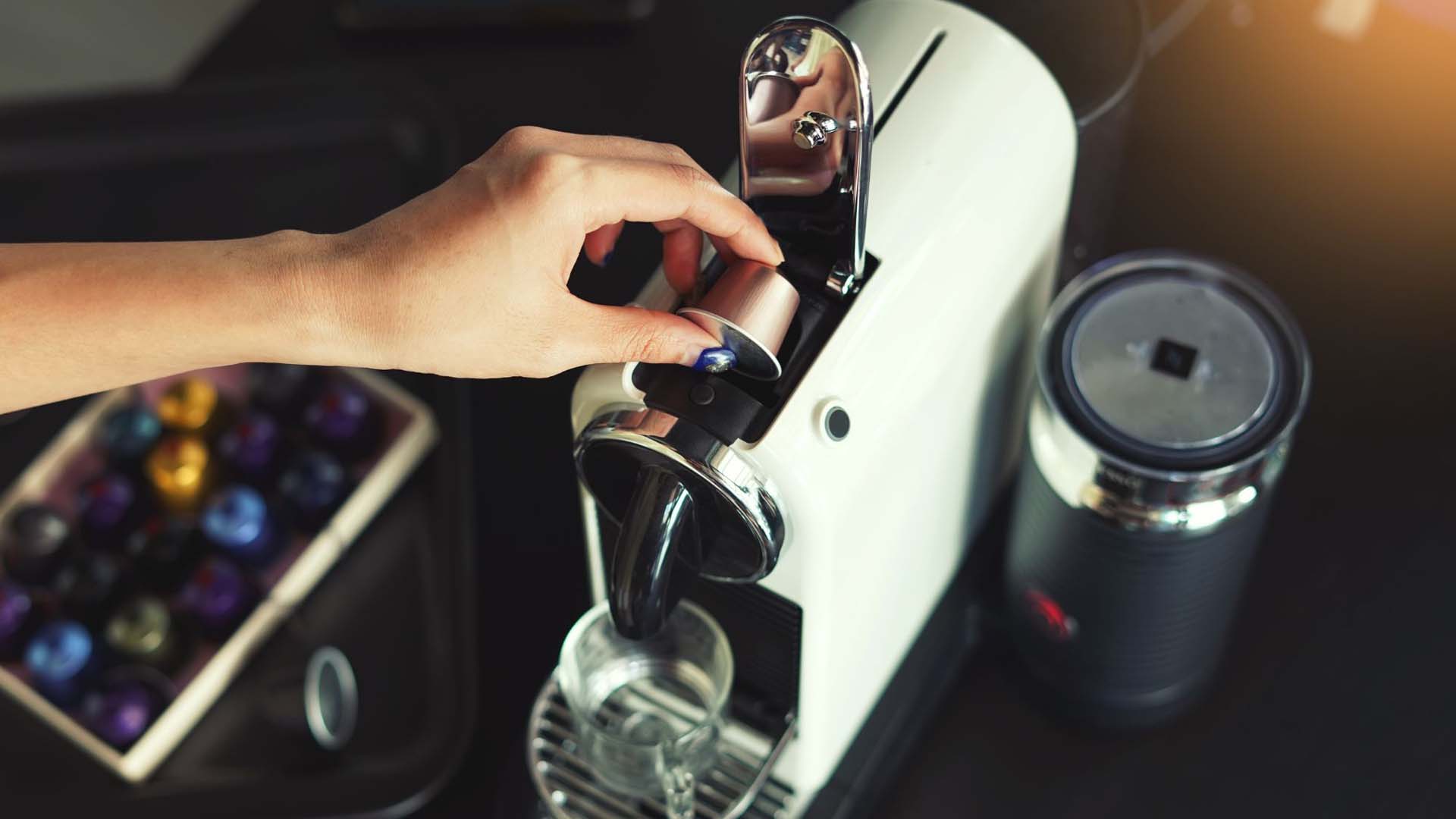 Close-up of someone placing a coffee pod into a coffee pod machine