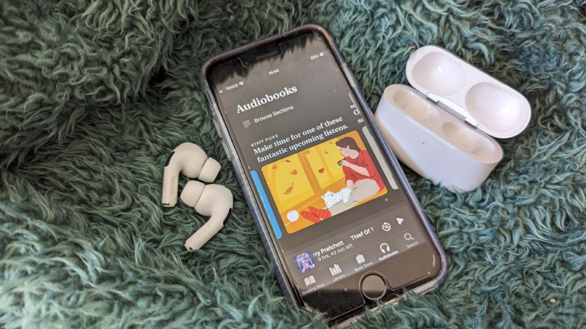 Apple AirpPods out of their case next to an iPhone