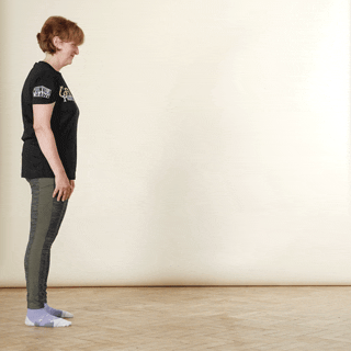 A woman in sports clothing demonstrating an inchworm exercise