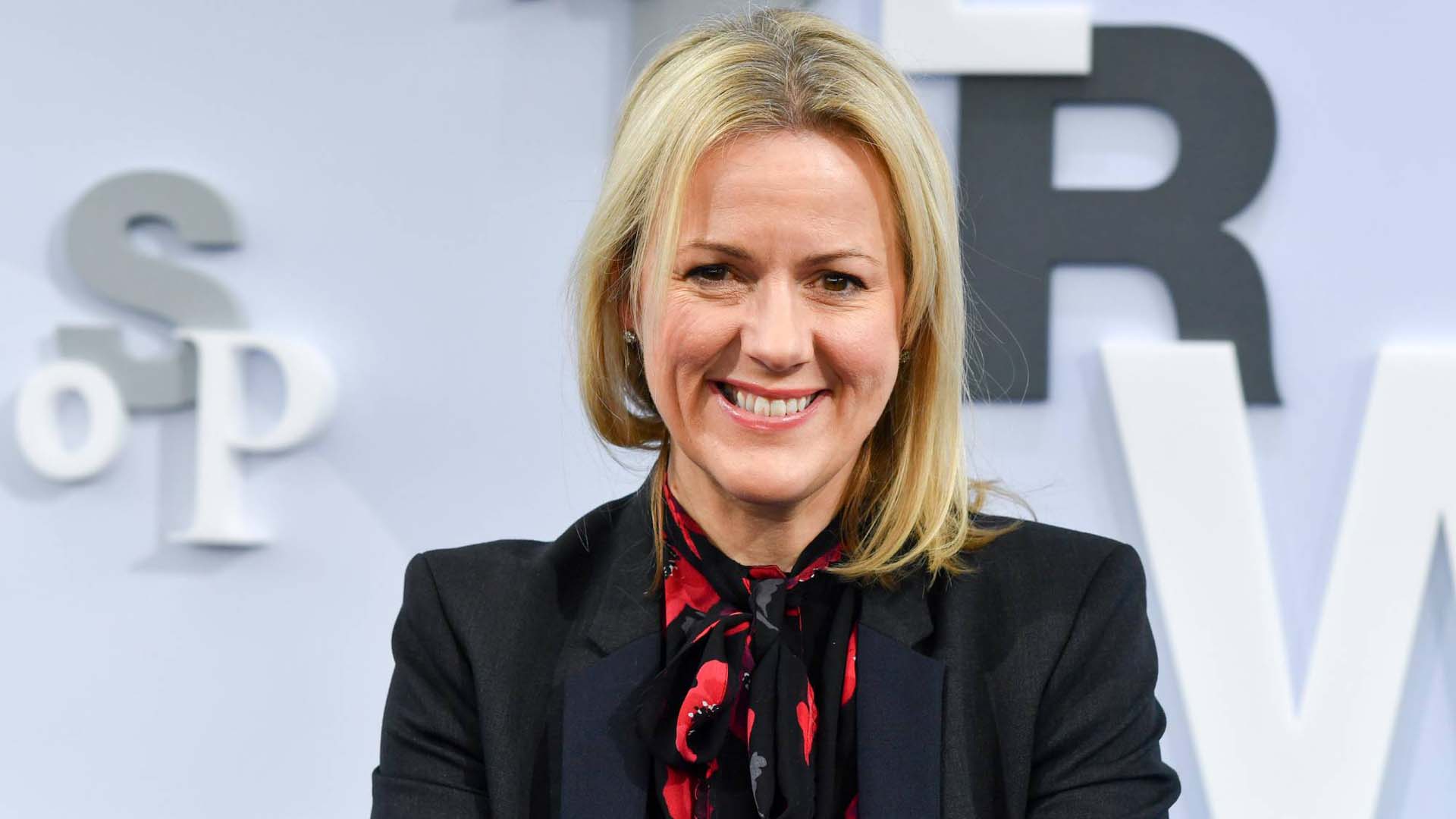 author Jojo Miles at a podium with a plain backdrop