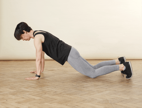 A clip of a woman demonstrating how to do a push up with knees on the floor