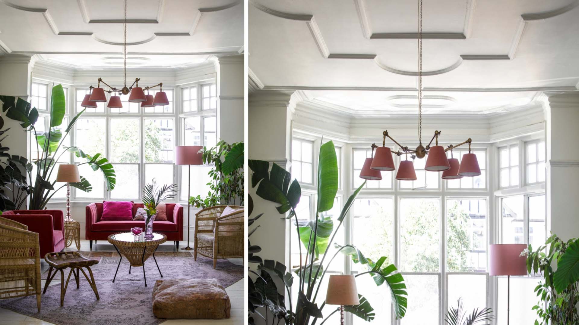 Large windows in a living space with red light shades and red sofa
