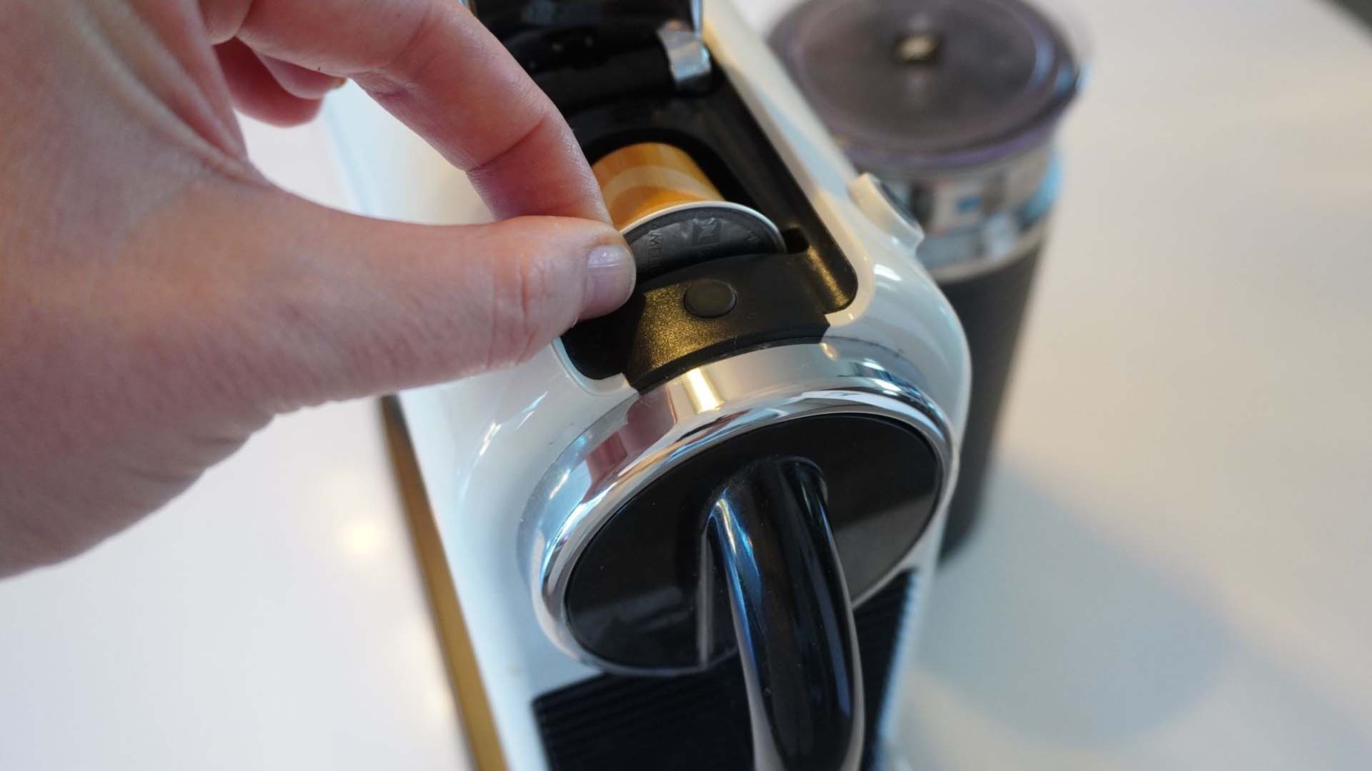 Close-up of someone placing a coffee pod into a coffee pod machine
