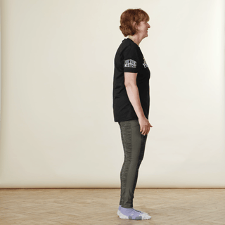 A woman in sports clothing demonstrating a reverse lunge