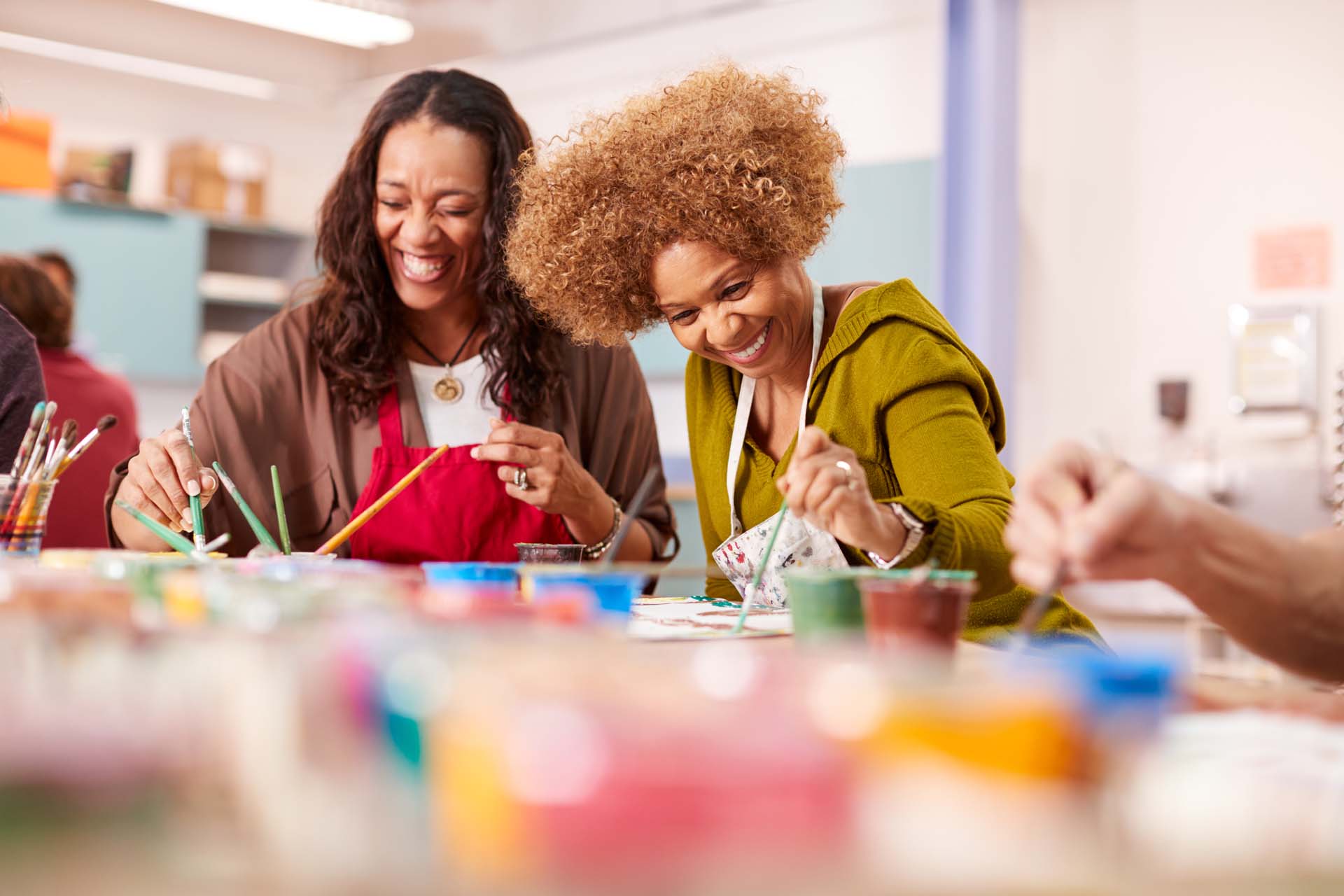 Two mature women attending art class in community centre together