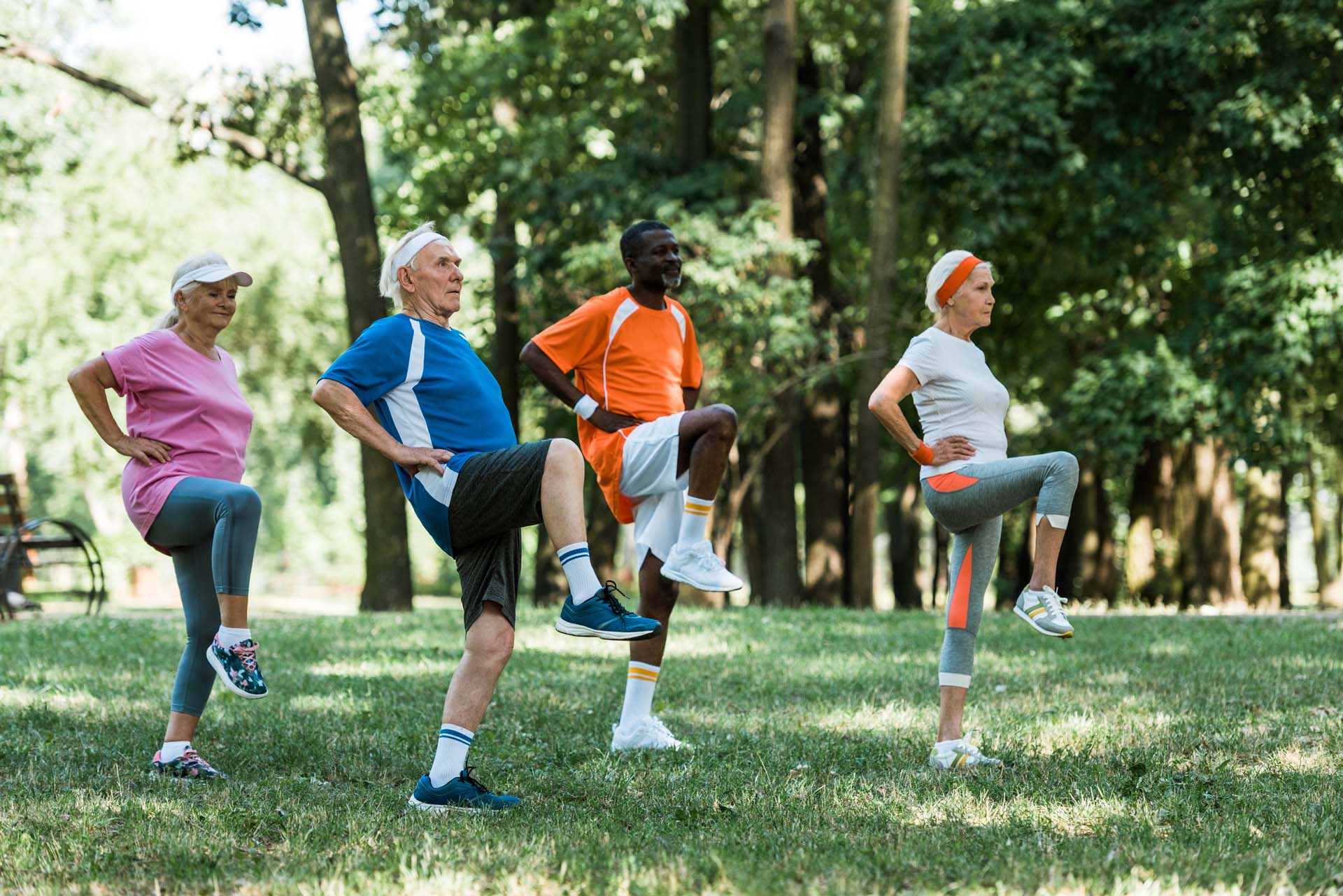 a group of people in a park all standing on one leg