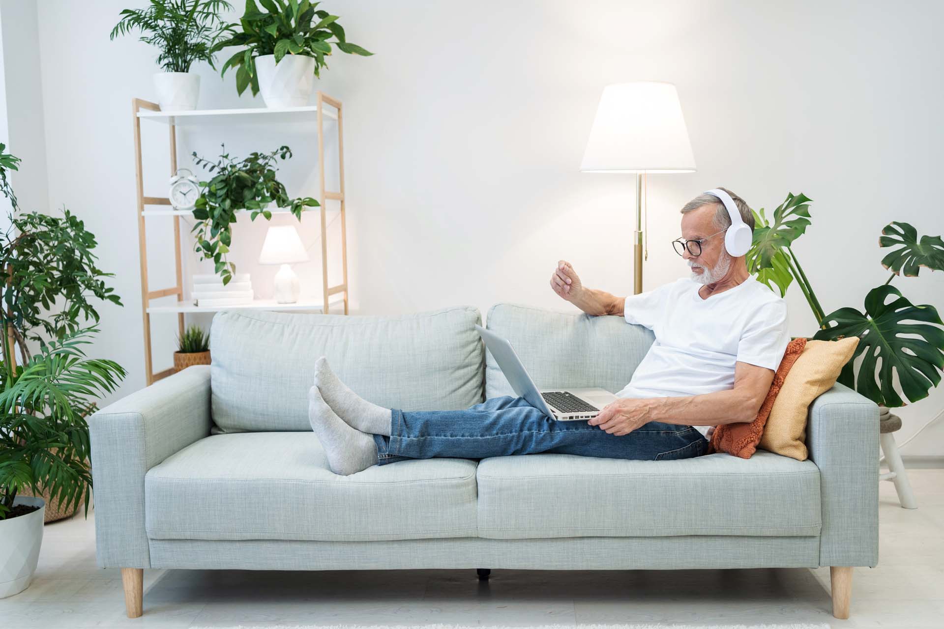 Man lying on the sofa with headphones on