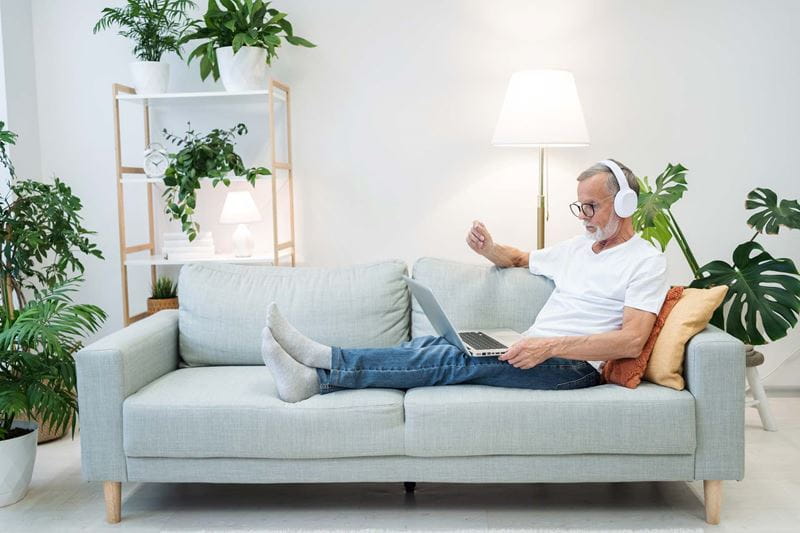 Man lying on the sofa with headphones on