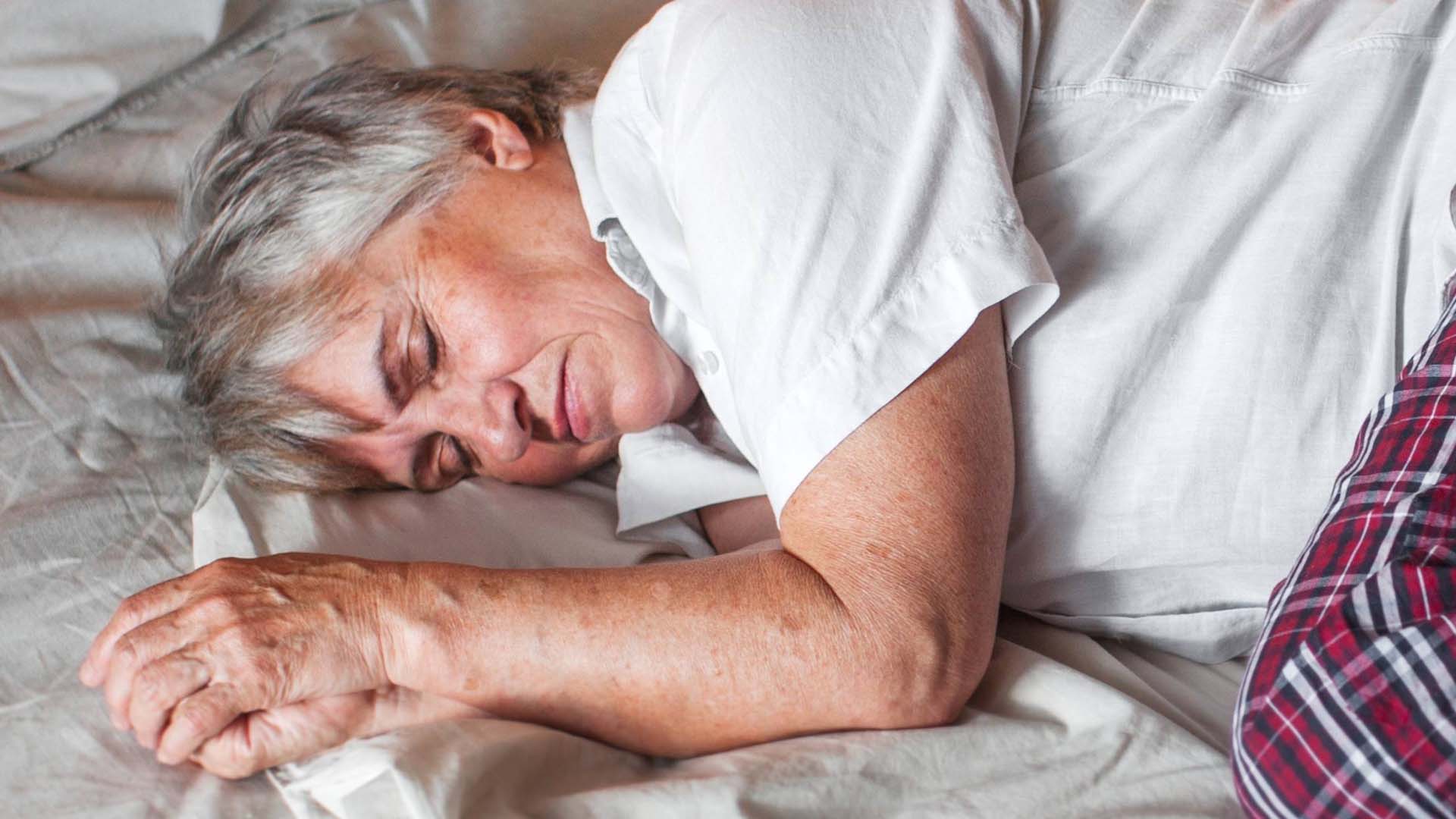 person in their pjs sleeping without a pillow