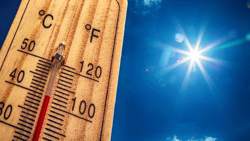 A picture of a thermometer reading 40 degrees celcius, with a blazing sun in the background