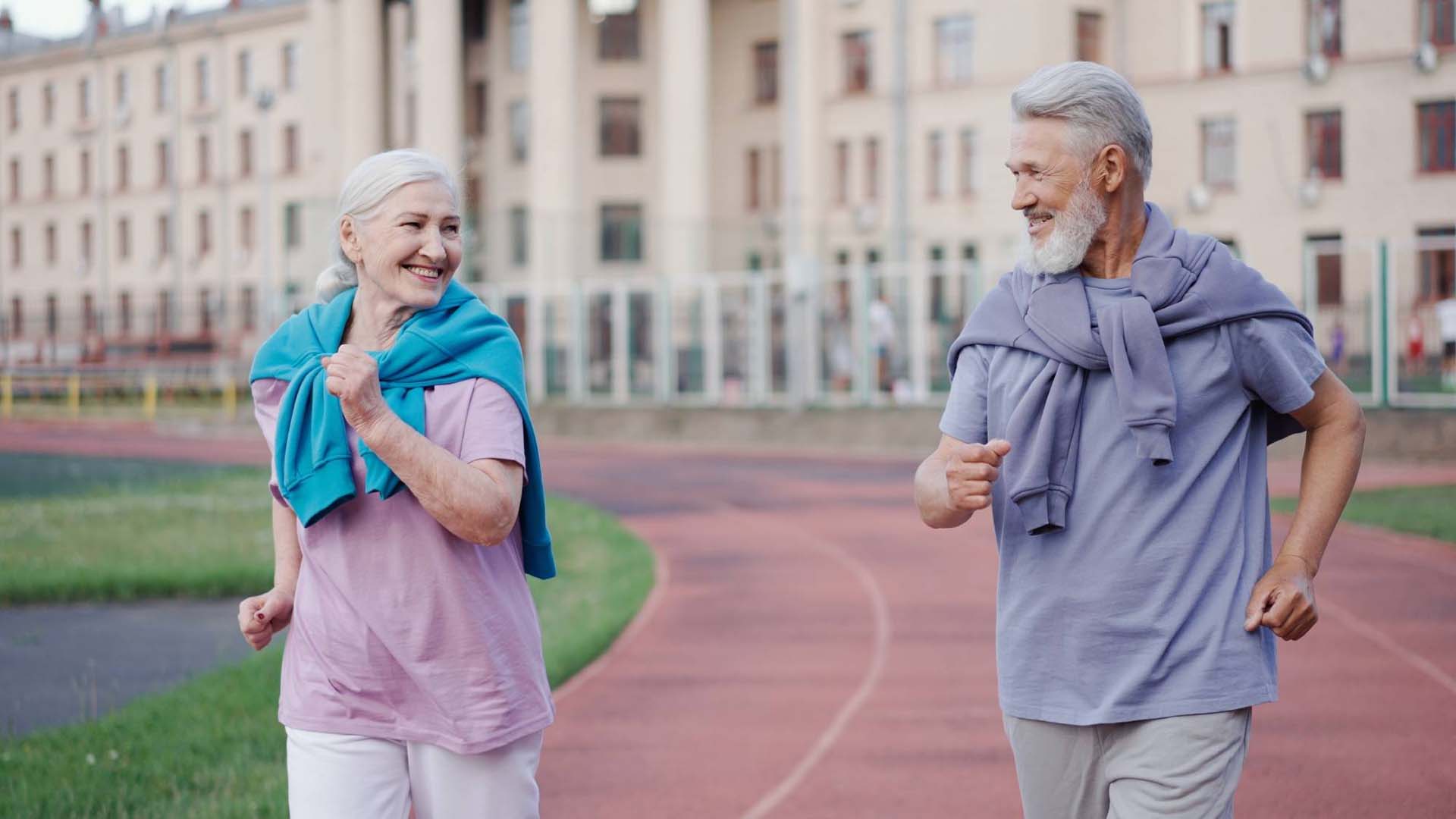 man and woman walking fast round a track