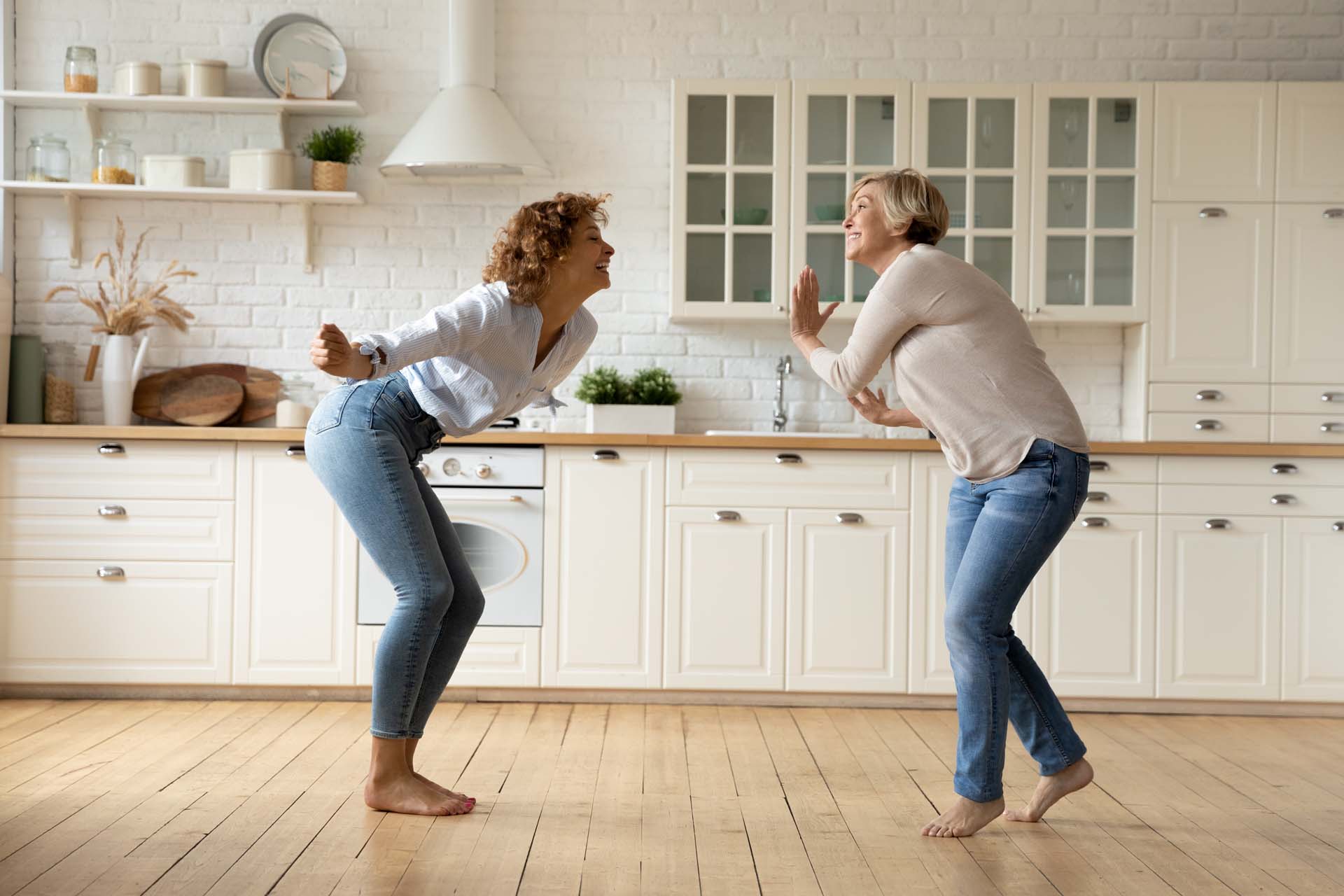 A couple of women dancing in a kitchen