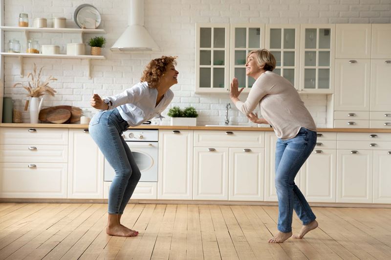 A couple of women dancing in a kitchen