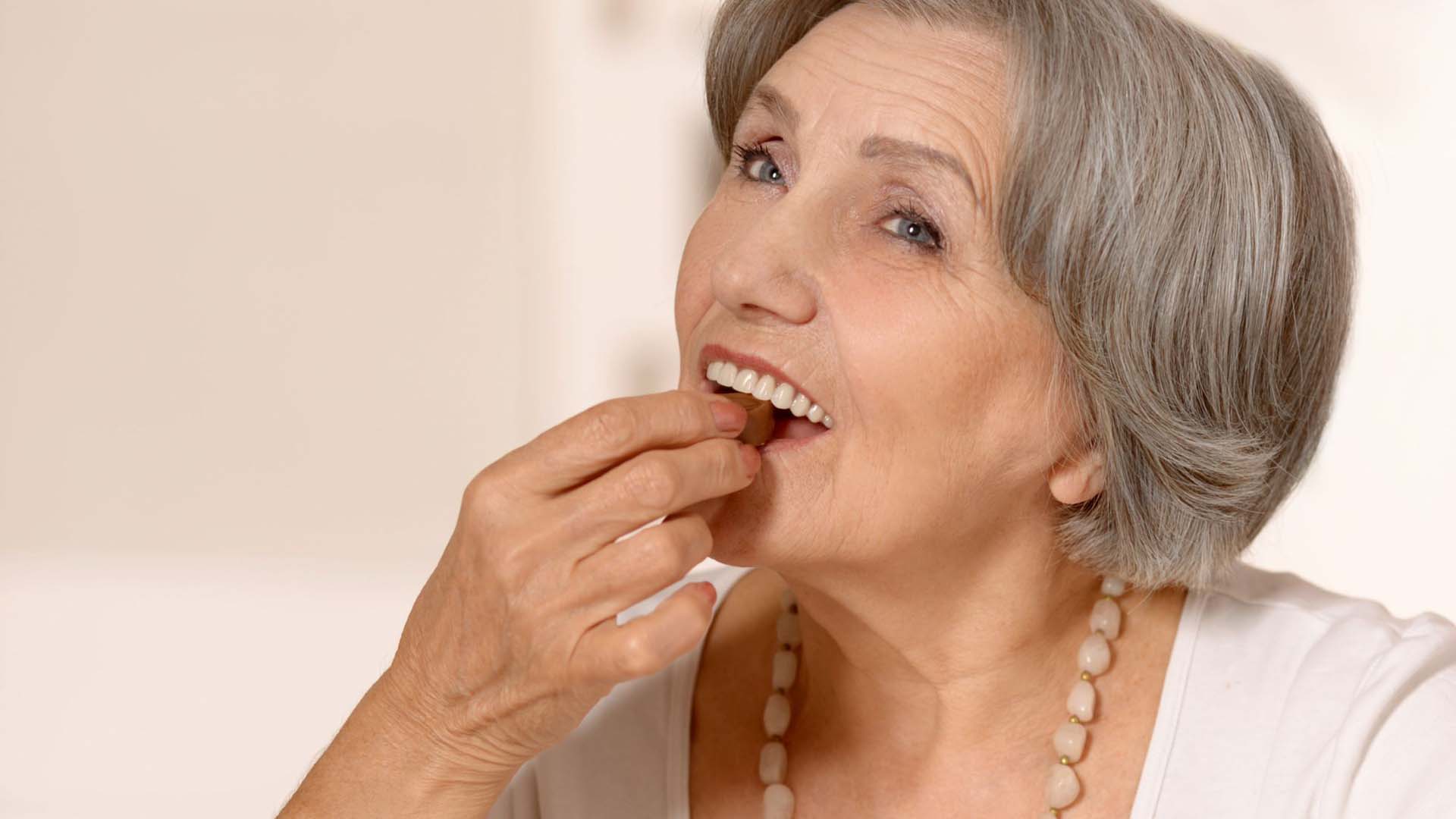 Mature women eating chocolate