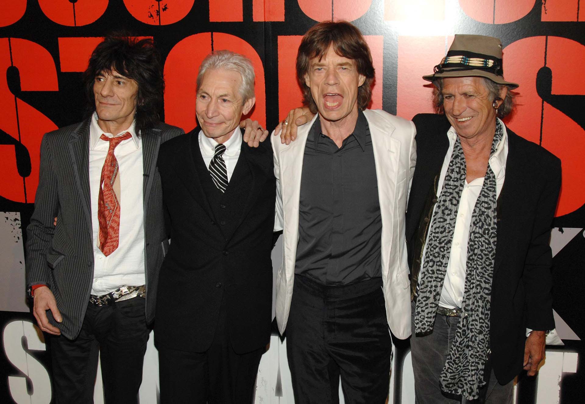 The four members of the rock band The Rolling Stones posing for photographs at an event