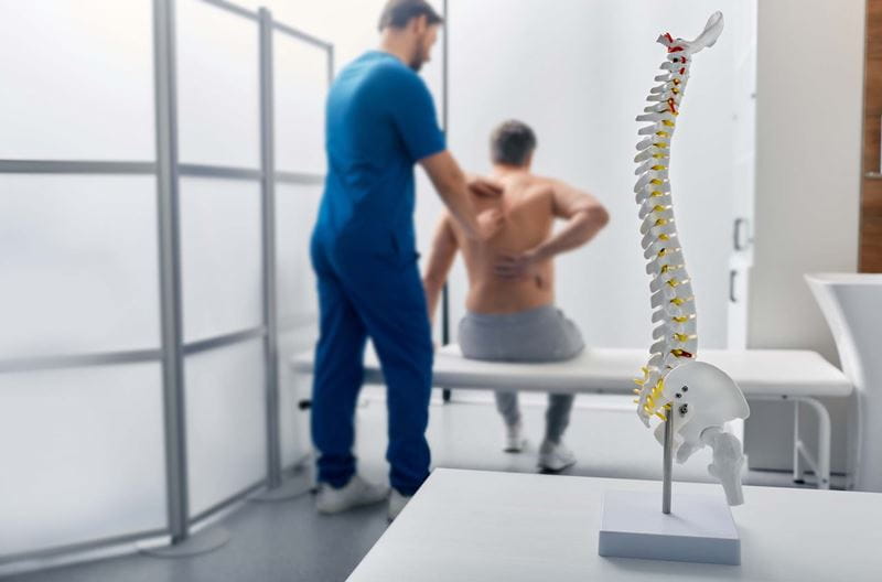 A chiropractor helps a man with back pain