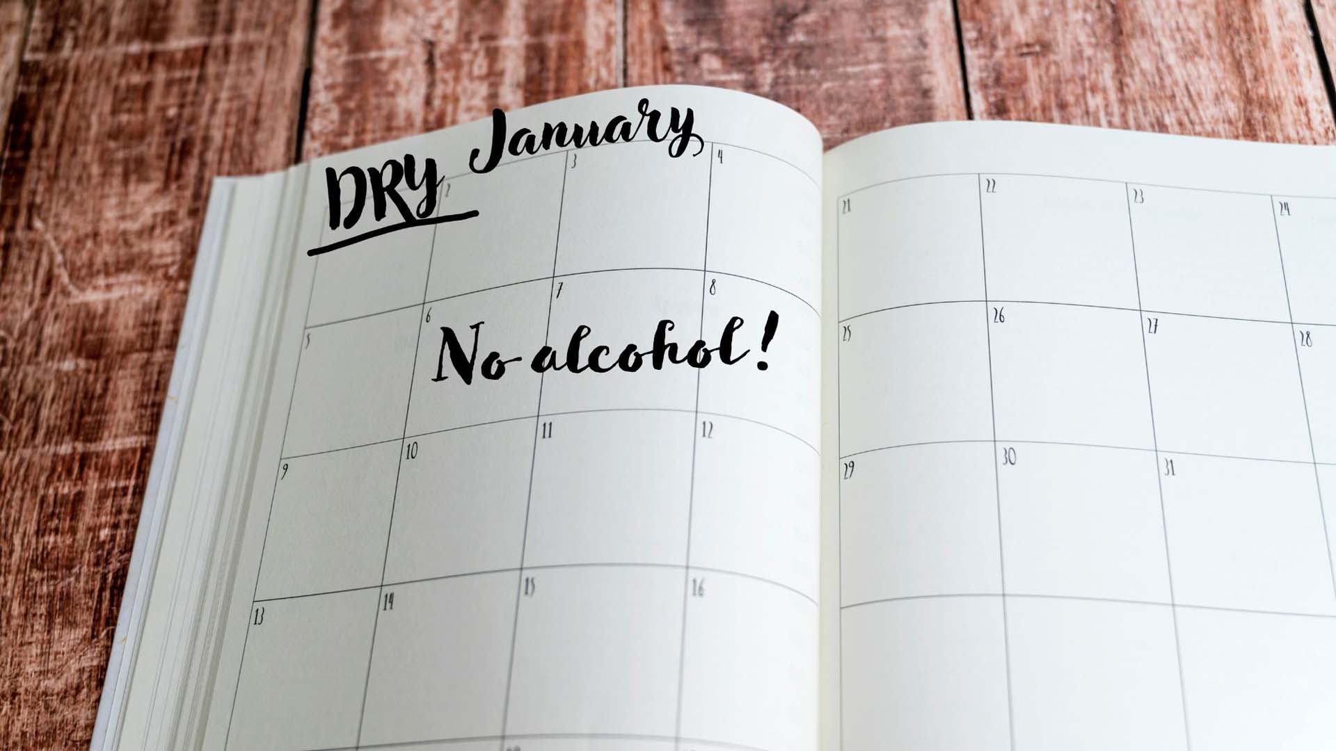 An open diary with the words 'Dry January, No alcohol' written over the top