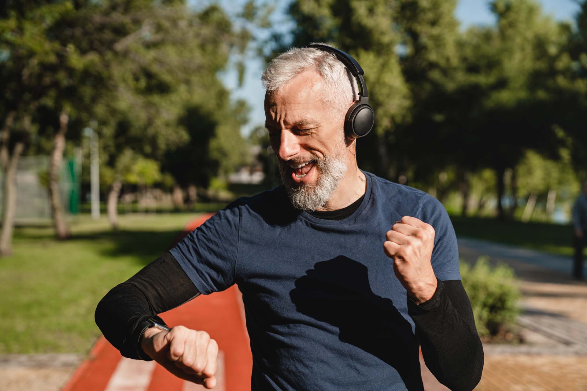 An older man accomplishing a running goal and cheering