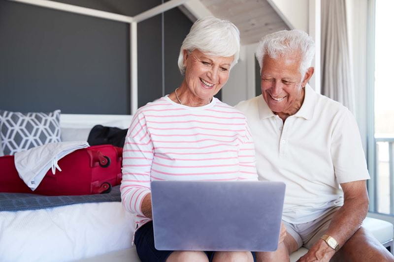 An older couple look online for holiday inspiration