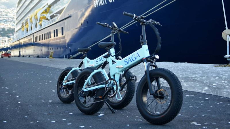 Two Saga Cruise ebikes parked next to the ship