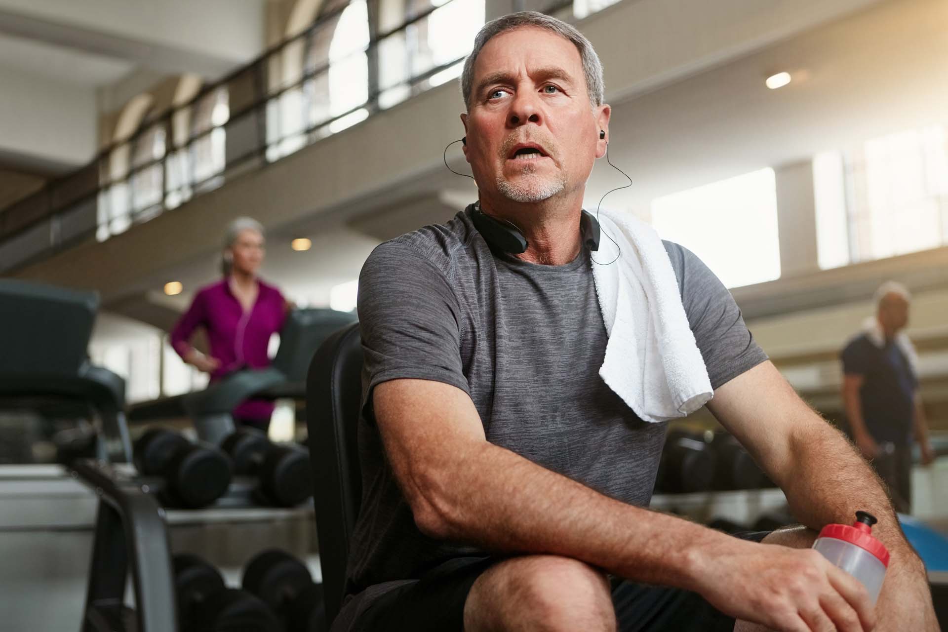 A man takes a break from exercising in a gym