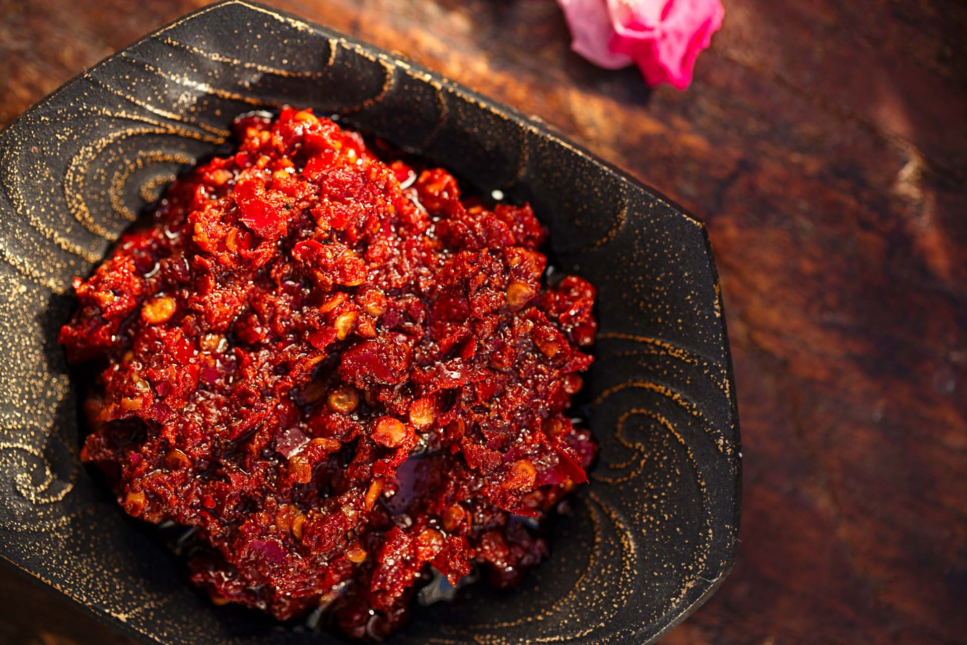 A bowl of red harissa on a wooden table
