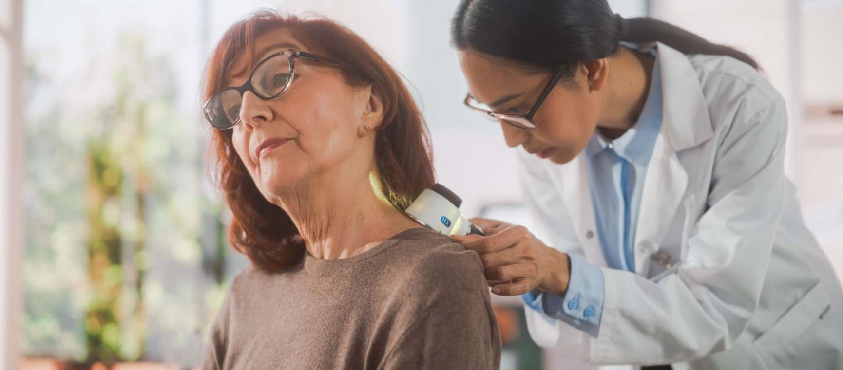 Doctor checking a mole on a lady