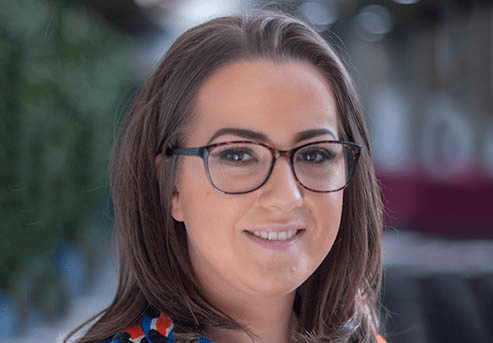 Headshot of a person with long hair wearing glasses