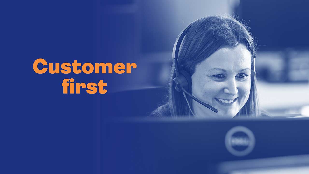 dark blue background with woman on a call in front of a computer. Text reads: customer first