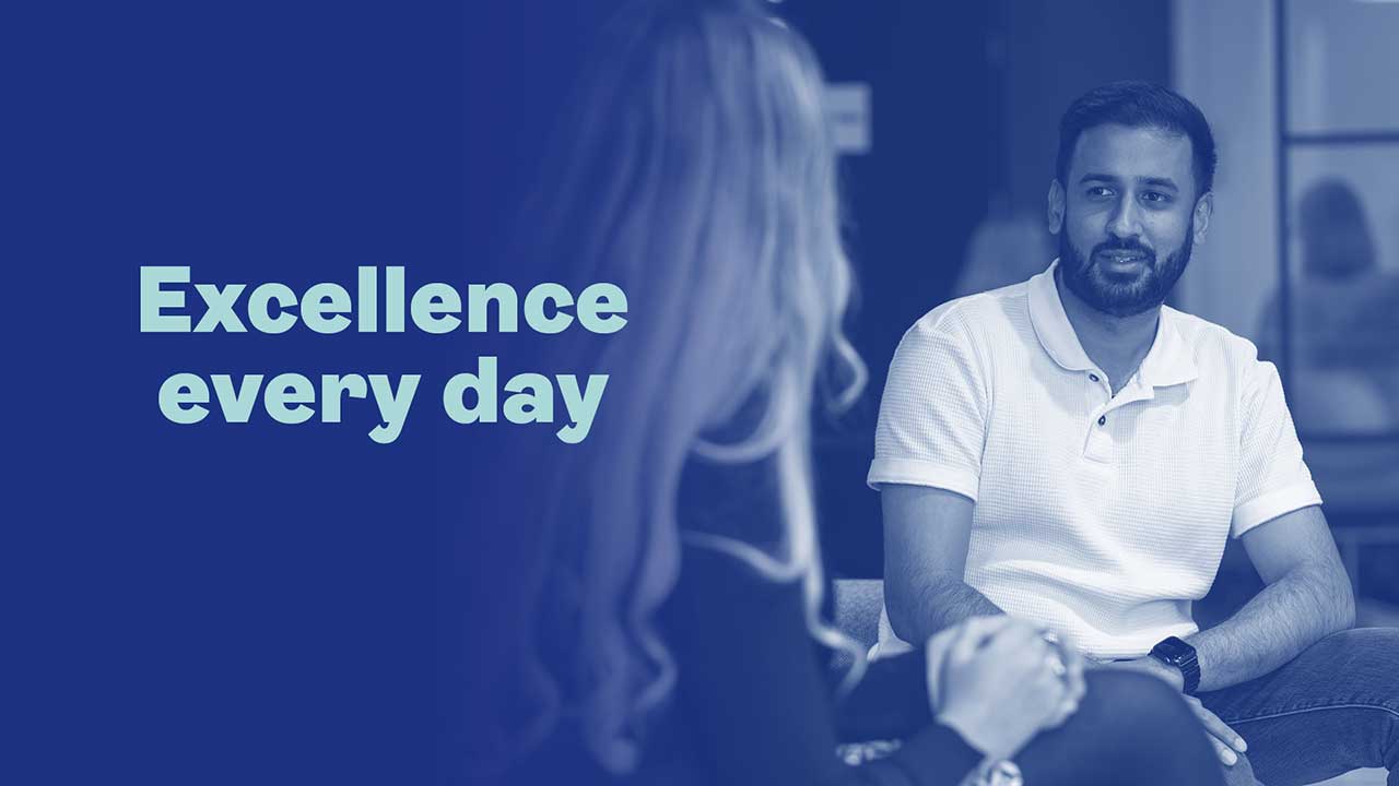dark blue background with man talking to woman. Text reads: excellence every day
