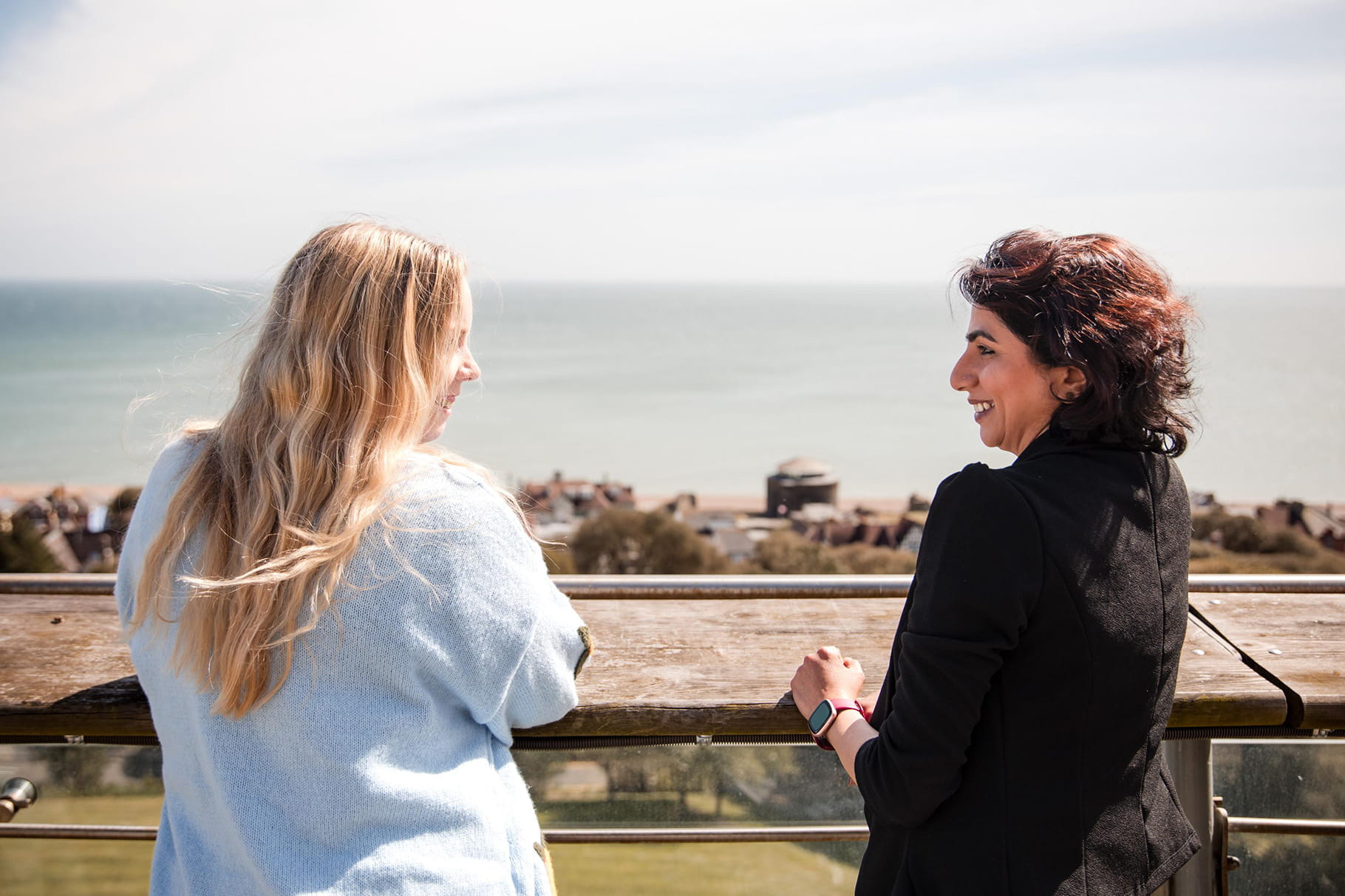 Two colleagues look out over balcony at Enbrook