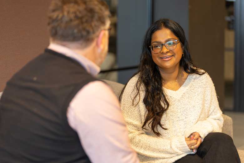Man with back to camera talking to woman